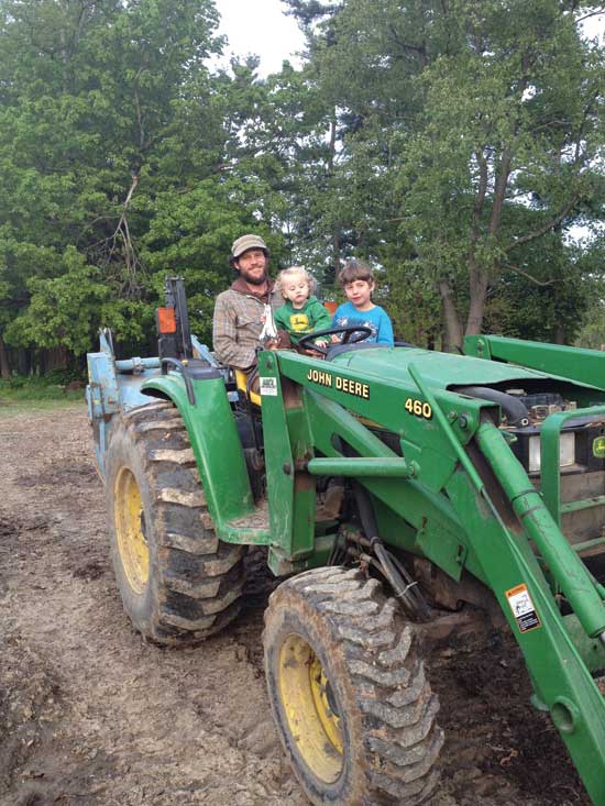Eric and the kids pose on their John Deere tractor.